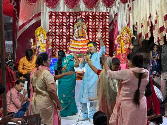 A singer of the party leading Khatu Shyam bhajans before Shyam Baba's flower-decked darbar as devotees dance