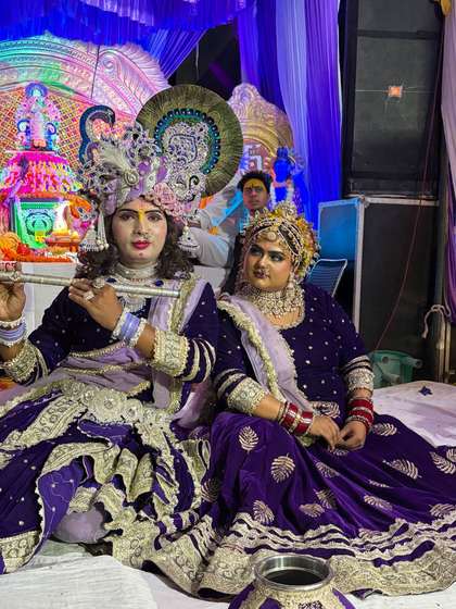 Artists dressed as Radha and Krishna, Krishna playing the flute, at a Krishna bhajan evening