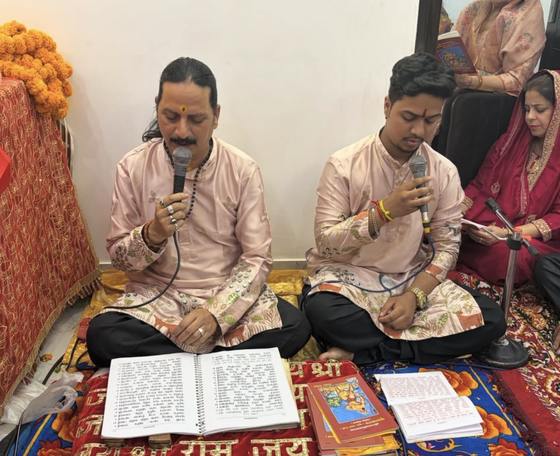 Prem Bhatnagar ji and a young singer of the party reciting the Sunderkand into microphones, with the Ramcharitmanas open in front of them