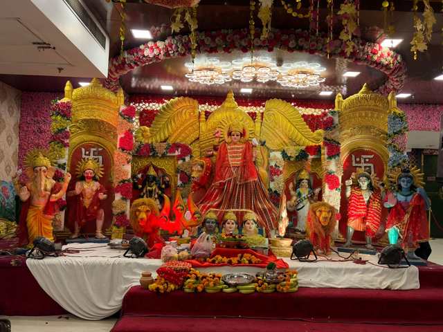 Mata's darbar in a banquet hall, Durga Mata in a red chunri with her lions, the jyot and marigold offerings in front