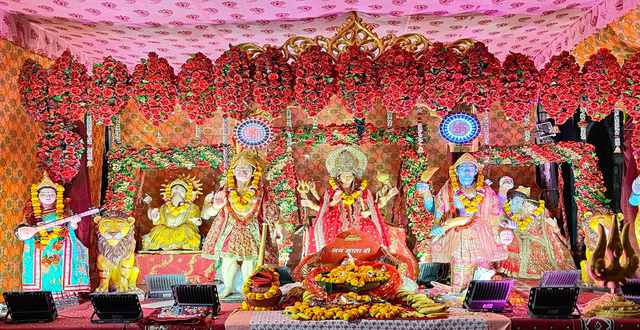 Mata's darbar for a jagran, with Durga Mata at the centre among Ganesh ji, Hanuman ji, Shiv ji and Saraswati Mata, hung with red roses