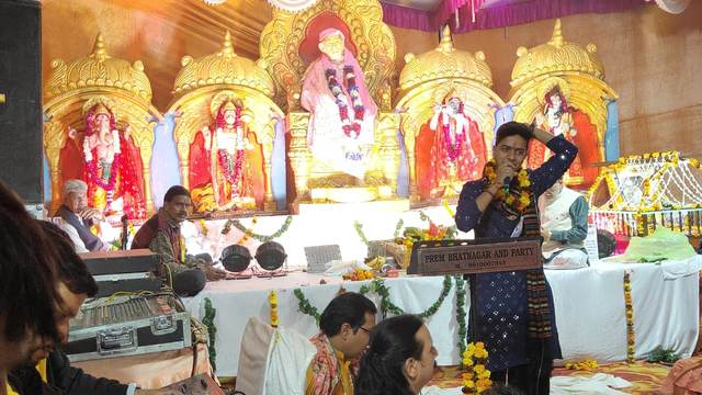 A singer of the party performing before Sai Baba's golden darbar at an evening Sai Sandhya