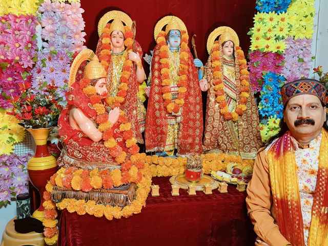 Prem Bhatnagar ji seated beside Ram ji, Sita Mata, Lakshman ji and Hanuman ji, garlanded with marigolds for a Sunderkand Path