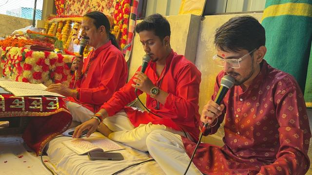 Prem Bhatnagar ji and two singers of the party in red kurtas reciting the Sunderkand together into microphones